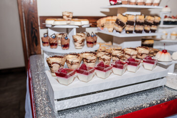 Sweet cakes at a wedding banquet. Catering, sweet festive buffet. Candy bar
