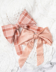 Pink and blush hair clip bows on white lace background