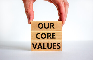 Our core values symbol. Concept words 'Our core values' on wooden blocks on a beautiful white background, businessman hand. Business and our core values concept. Copy space.