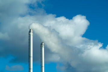 pipe against the blue sky, smoke coming out of the pipe