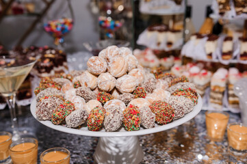 Sweet cakes at a wedding banquet. Catering, sweet festive buffet. Candy bar