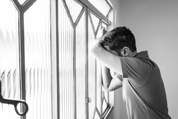 man with depression looking at the window