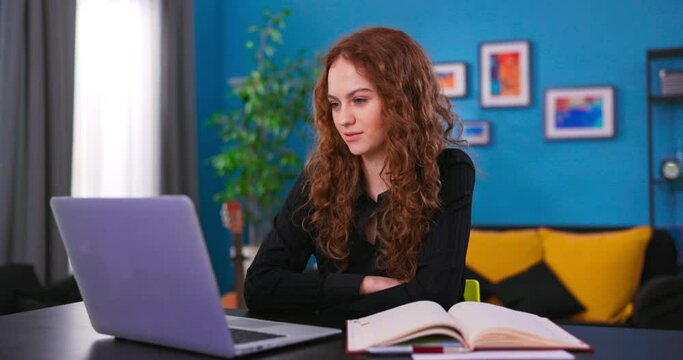Education and study at home. A young teenage girl using a laptop for studying, watching online lectures, workshops and master classes. Pretty woman chatting with friends on website communicator.