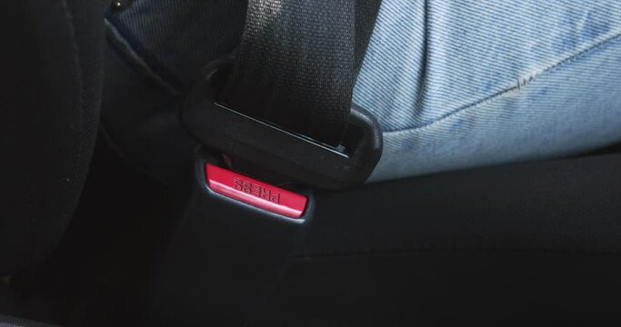 A woman fastens her seat belt in the car