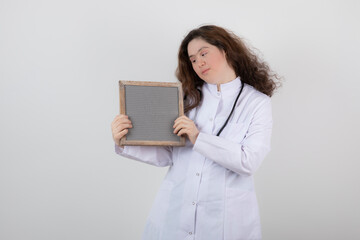 Picture of a young girl model in white uniform holding a frame