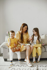 Mother with daughter and son at home. Make up a holiday basket. In festive clothes