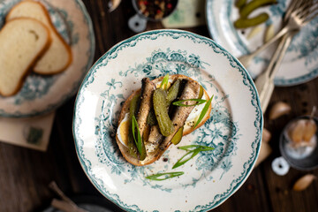 tasty open sandwiches with sprats, boiled eggs, onion on vintage plates. Russian cuisines