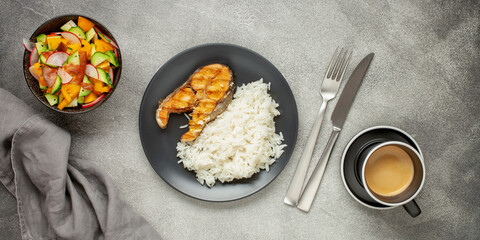 Fish salmon grill with rice and vegetables on a plate on the table. Top View