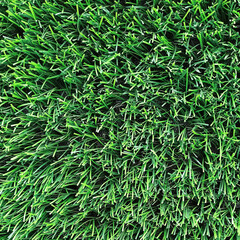 Bright green natural background. Artificial grass close-up.