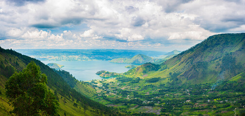 Naklejka premium Lake Toba and Samosir Island view from above Sumatra Indonesia. Huge volcanic caldera covered by water, traditional Batak villages, green rice paddies, equatorial forest.