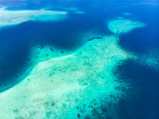 Naklejka premium Aerial: exotic tropical island white sand beach away from it all, coral reef caribbean sea turquoise water. Indonesia Sumatra Banyak islands