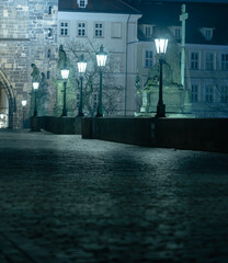 .Charles bridge. Lamps on the empty Charles Bridge on the Vltava river at night and the stone...