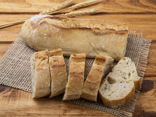 Traditional homemade french baguette bread with slices over wooden table