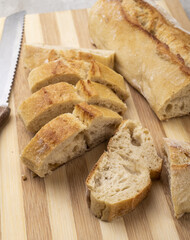 Traditional homemade french baguette bread with slices over wooden board