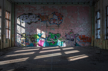 Abandoned Soviet time swimming pool and sports hall complex. Colorful graffiti paintings on the walls. Urban exploration.