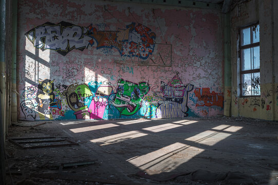Abandoned Soviet time swimming pool and sports hall complex. Colorful graffiti paintings on the walls. Urban exploration.