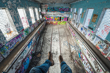 Naklejka premium Abandoned Soviet time swimming pool and sports hall complex. Colorful graffiti paintings on the walls. Urban exploration.