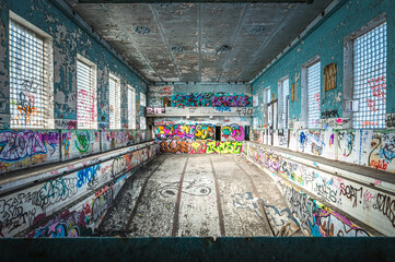 Abandoned Soviet time swimming pool and sports hall complex. Colorful graffiti paintings on the...