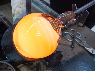 Man Hands Closeup Shaping Blown Glass Piece with a Wet mold