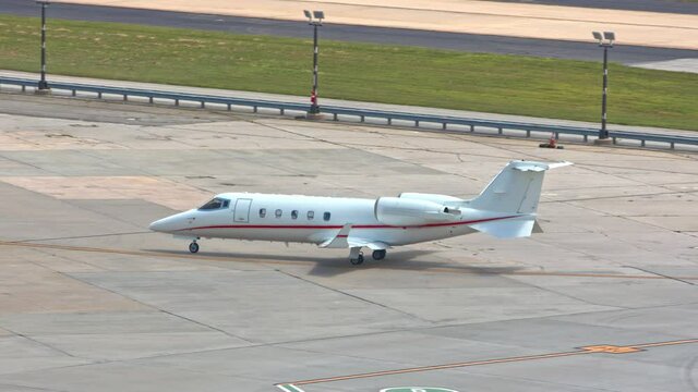 Generic Unmarked Business Executive VIP Jet Airplane on Platform Taxiing to International Airport Hangar on a Sunny Day