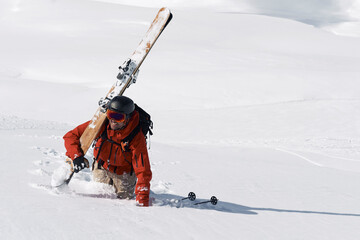 Male skier trudging up mountain through deep snow, Alpe-d'Huez, Rhone-Alpes, France