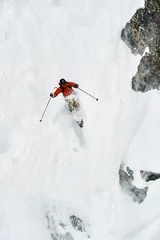  Male skier skiing down vertical mountainside, Alpe-d'Huez, Rhone-Alpes, France © Image Source