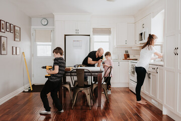 Family of four busy with chores in kitchen