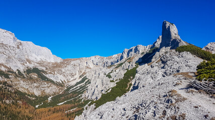Panoramic view on mountains in Hochschwab region, Austrian Alps. The flora overgrowing slopes is turning golden. Autumn vibes in the mountains. Sharp and high peaks. Freedom and wilderness