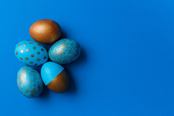 Blue and golden modern easter eggs on a white background. Top view. Easter concept. Isolated.