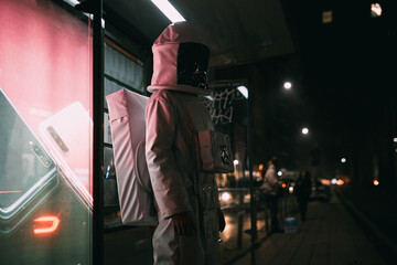 Astronaut standing at illuminated bus stop