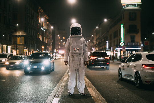 Astronaut in middle of busy street at night