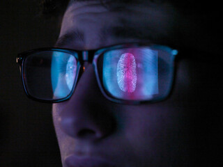 Cyber Security, reflection in spectacles  of access information being scanned on computer screen, close up of face