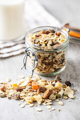 Beakfast cereals on kitchen table. Healthy muesli with oat flakes, nuts and raisins