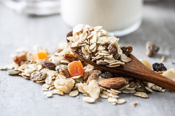 Beakfast cereals in wooden scoop. Healthy muesli with oat flakes, nuts and raisins