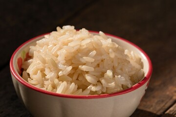 Cooked brown rice in the bowl was placed on the wooden floor.