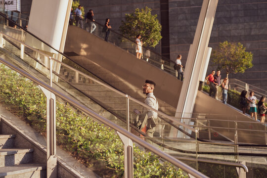 Businessman ascending escalator of office building, Milano, Lombardia, Italy - Powered by Adobe