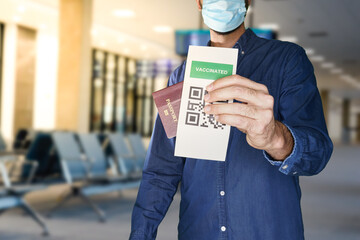 unidentified manwearing a face mask and holding a passport and a Green pass certificate of vaccination.The European Union will propose issuing a certificate called a Digital Green Pass
