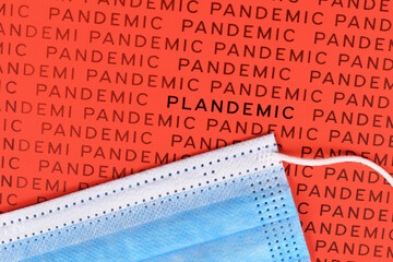 Word 'Plandemic' between lines wird word 'Pandemic' with medical face mask. Concept for conspiracy theories during Corona virus crisis