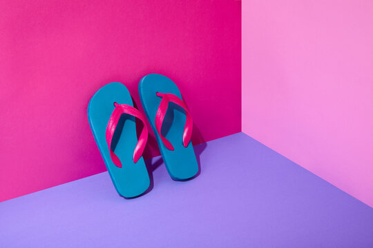 Pair of colourful flip-flops leaning on wall
