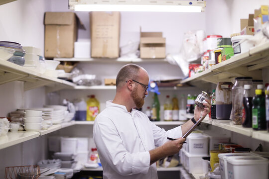 Chef checking stock of goods in storage room