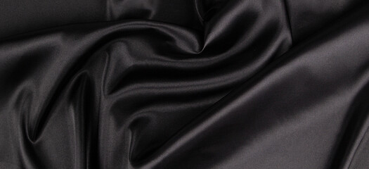 Fototapeta premium Beautiful elegant black background with drapery and wavy folds of silk satin material texture. Top view