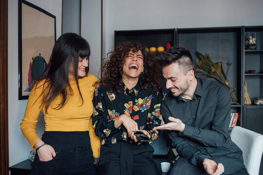 Friends using smartphone, laughing