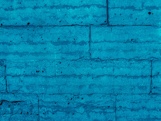 Fototapeta premium Brickwork of big bright blue bricks bonded with cement grout between geometric gorizontal square stones. Wall exterior. Background