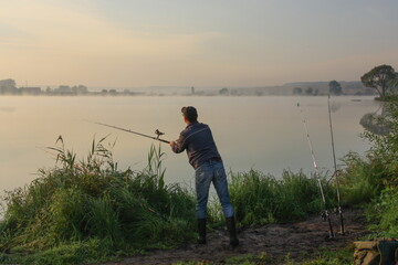 Man fishing on a lake with fog