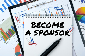 On the table are reports, charts, a notebook with the inscription - BECOME A SPONSOR