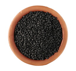 Black beluga lentils pile in clay pot isolated on white background, top view
