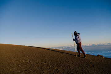 Climber on top of Acatenango volcano in Guatemala watching the sunset - woman hiking on top of the volcano at sunset