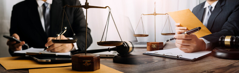 Business and lawyers discussing contract papers with brass scale on desk in office. Law, legal services, advice, justice and law concept picture with film grain effect