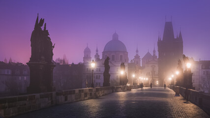 Fototapeta na wymiar A quiet Gothic Charles Bridge at dawn with a moody, foggy atmosphere in old town Prague, Czech Republic.