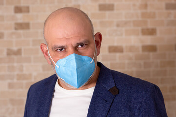 Man wearing face mask looking in to the camera.